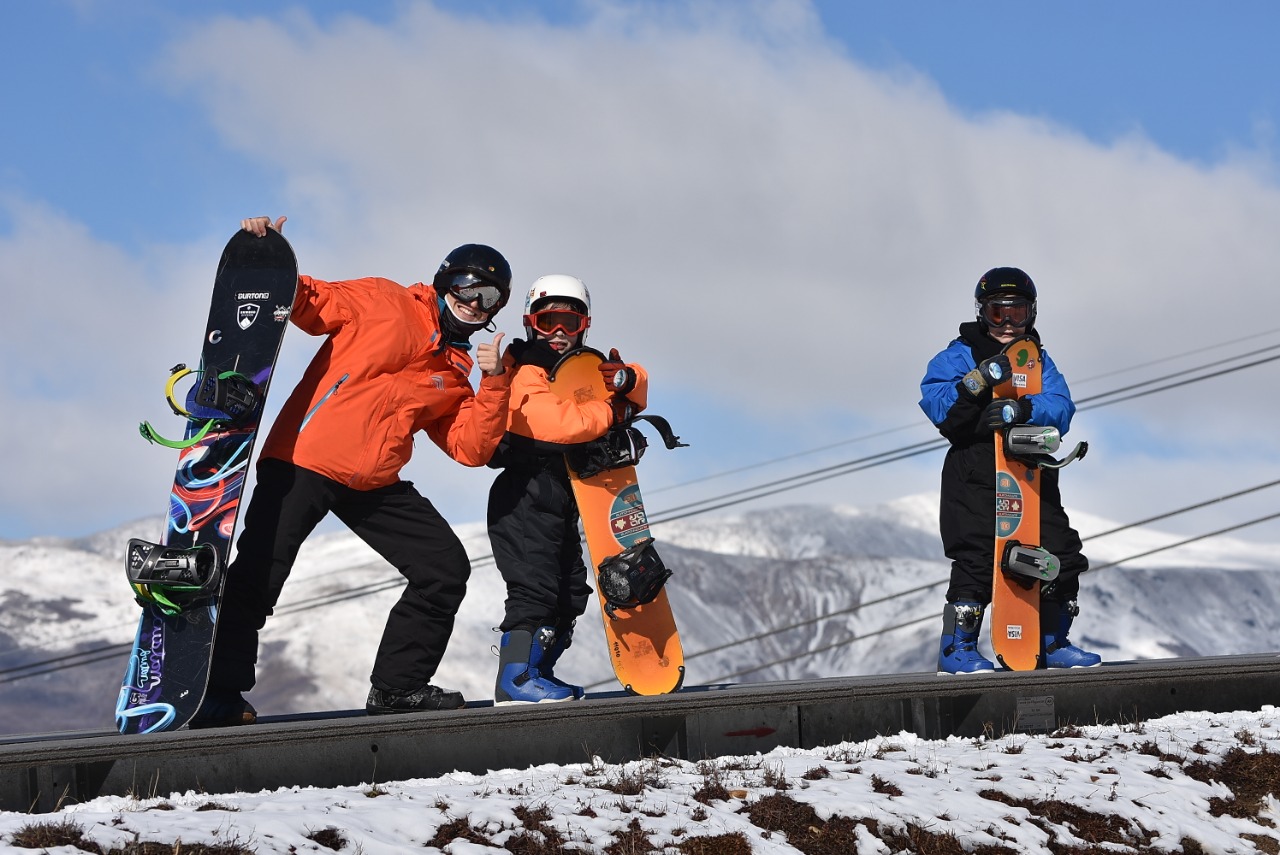 Personas con tablas de snowboard