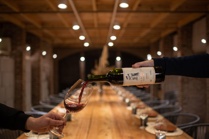 Botella y copa de vino en Bodega Gamboa