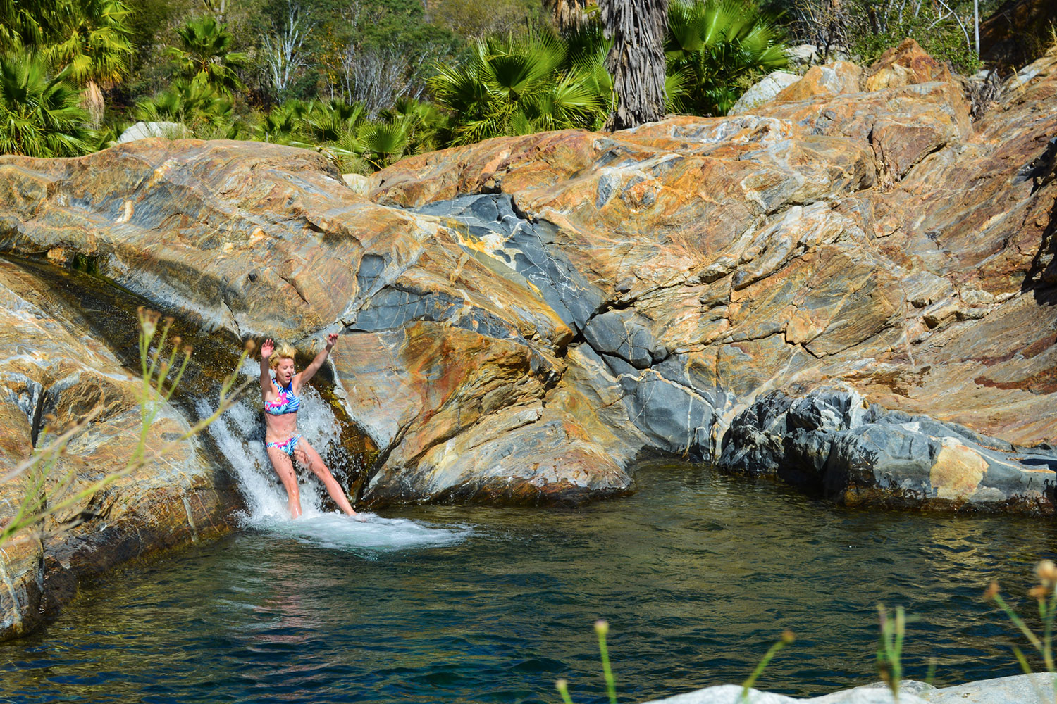 Persona deslizándose a piscina natural