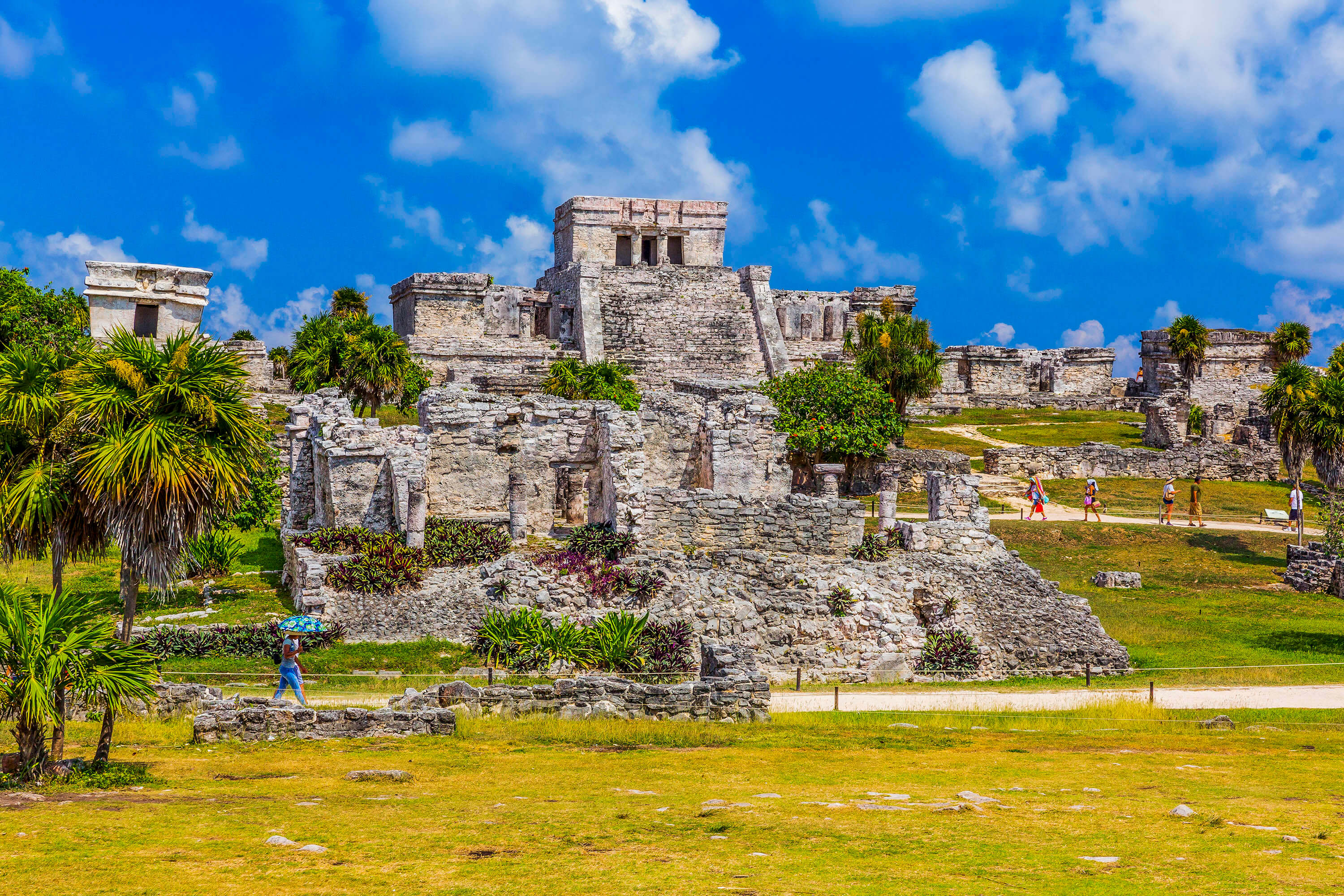 Vista panorámica de la zona arqueológica de Tulum con El Castillo maya entre palmeras tropicales