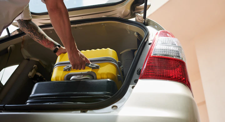 Hombre subiendo maleta al automóvil
