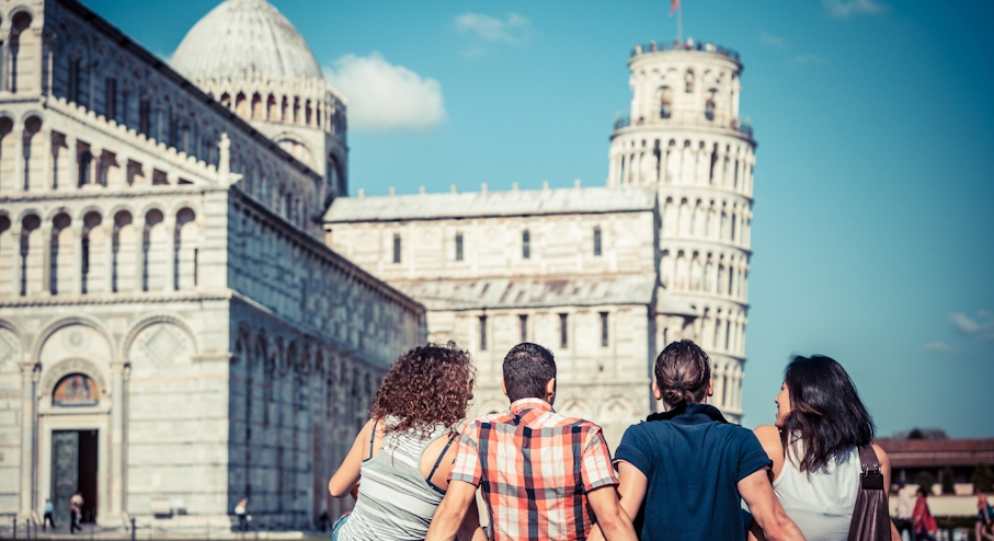 Gente sentada frente a la Torre de Pisa