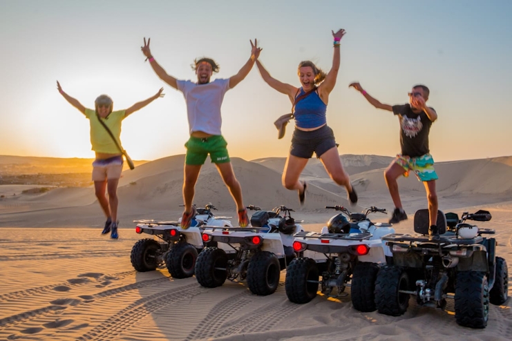 Personas saltando de ATV en el desierto de Ica
