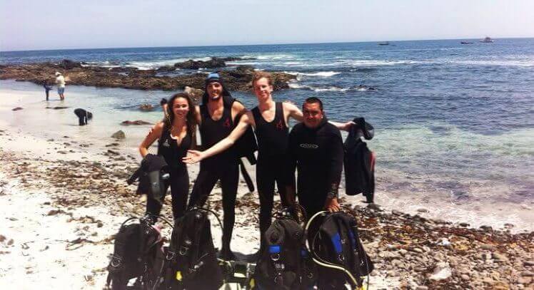 Grupo en playa de Iquique con equipo de buceo.