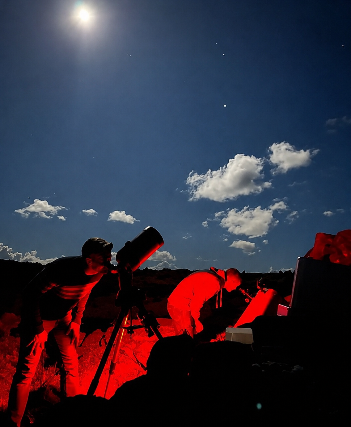 Participantes observan el cielo con telescopios e iluminación roja durante tour astronómico nocturno en Rapa Nui