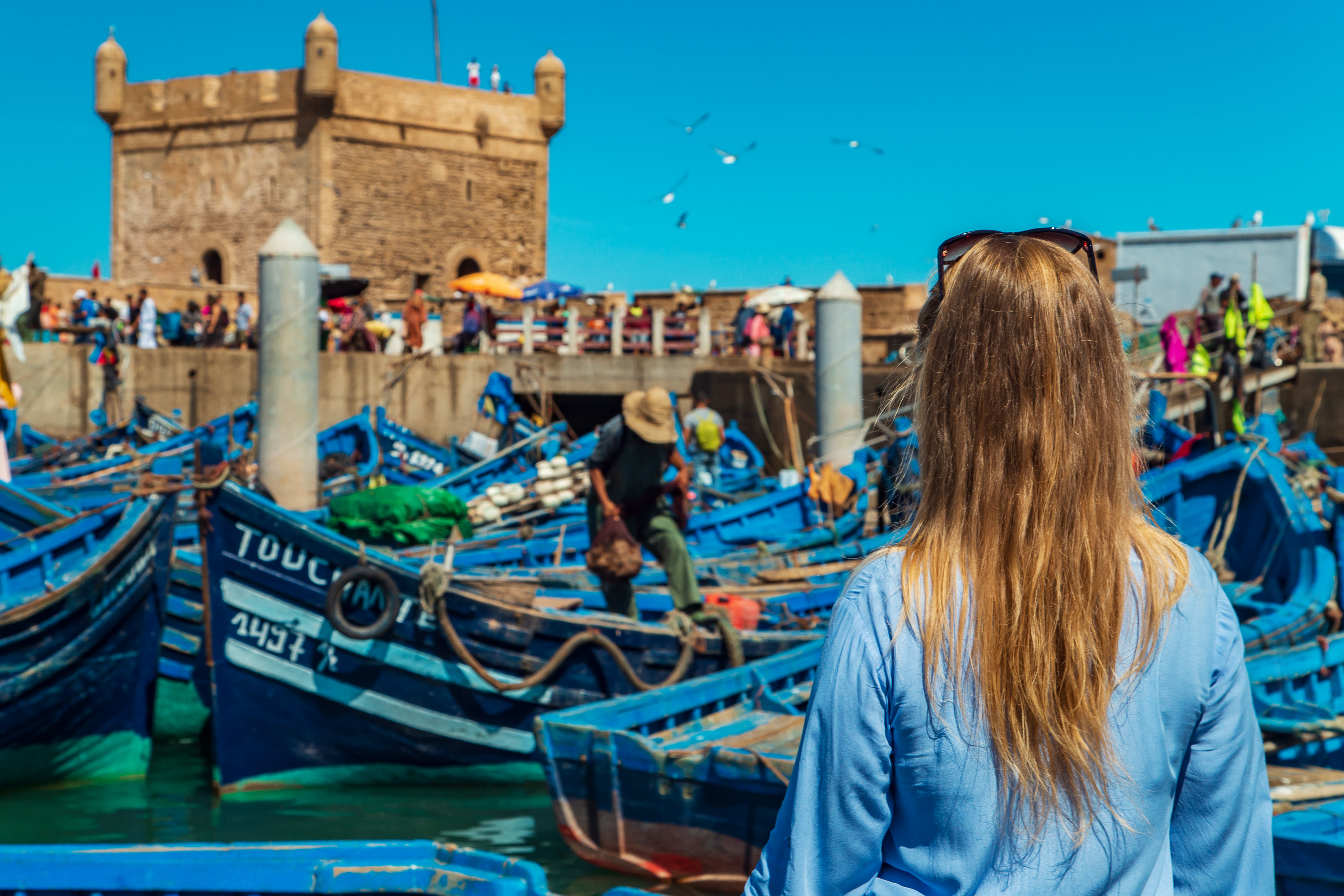 Mujer viendo el puerto pesquero