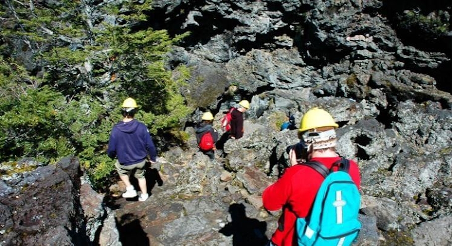 Excursionistas entrando a las cuevas volcánicas.