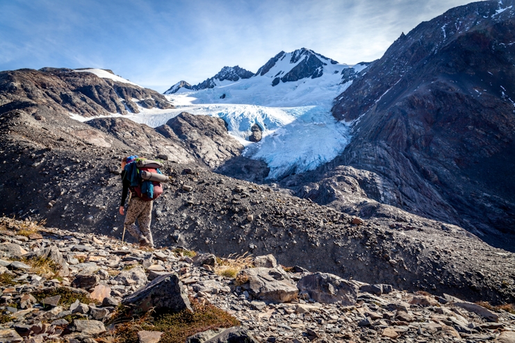 Persona haciendo trekking y glaciar de fondo