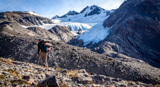 Persona haciendo trekking y glaciar de fondo