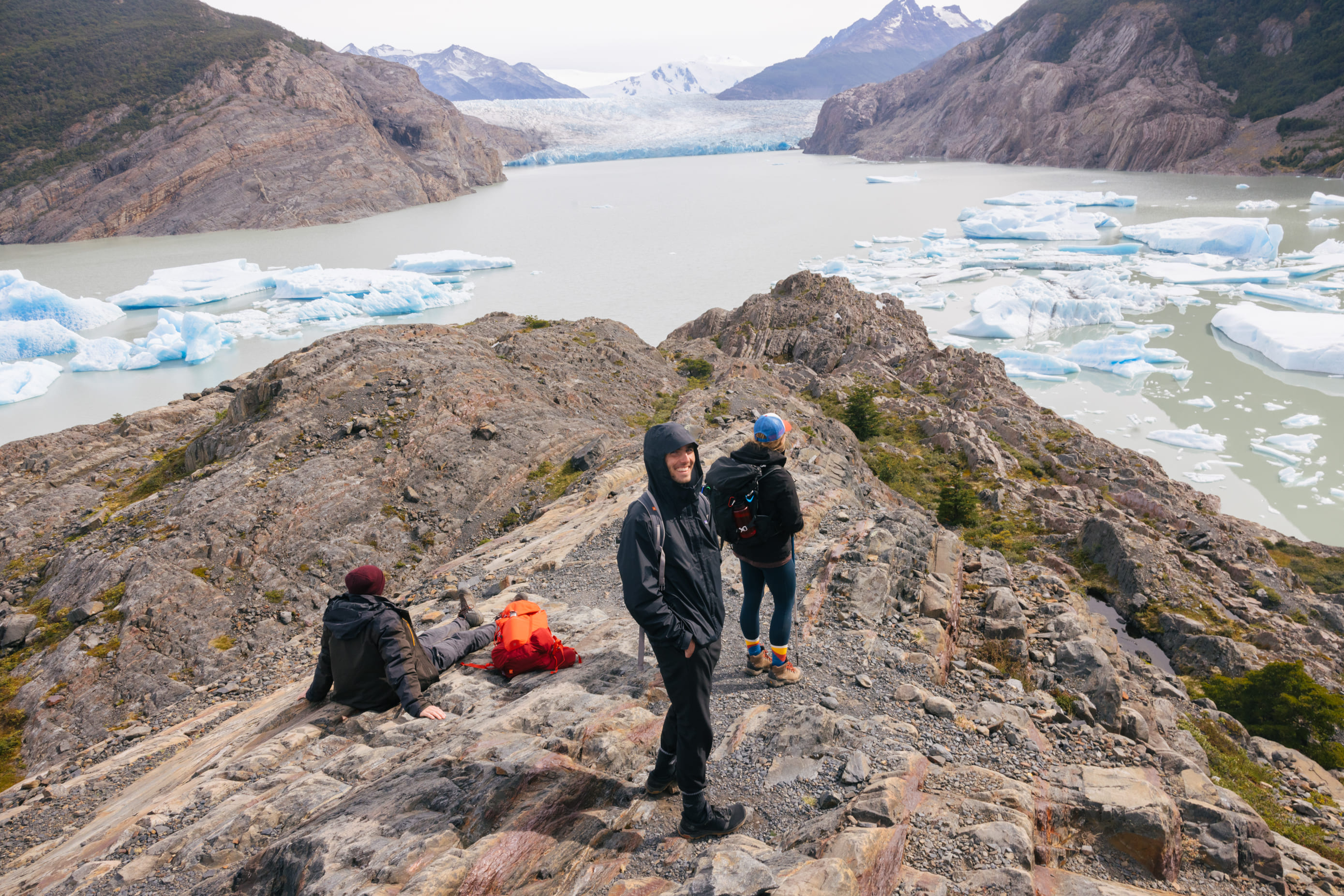 Pasajeros en la roca mirando la vista panorámica del lago y el glaciar Grey