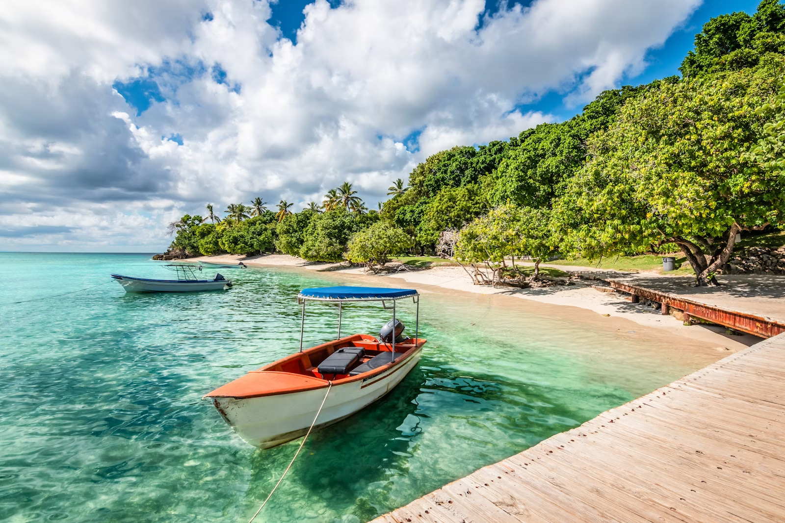 Lancha amarrada junto a un muelle de madera en aguas turquesa de Isla Bacardí, República Dominicana