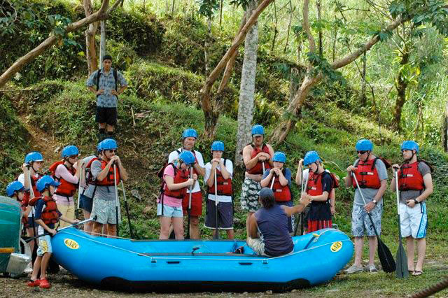 Personas recibiendo instrucciones de rafting