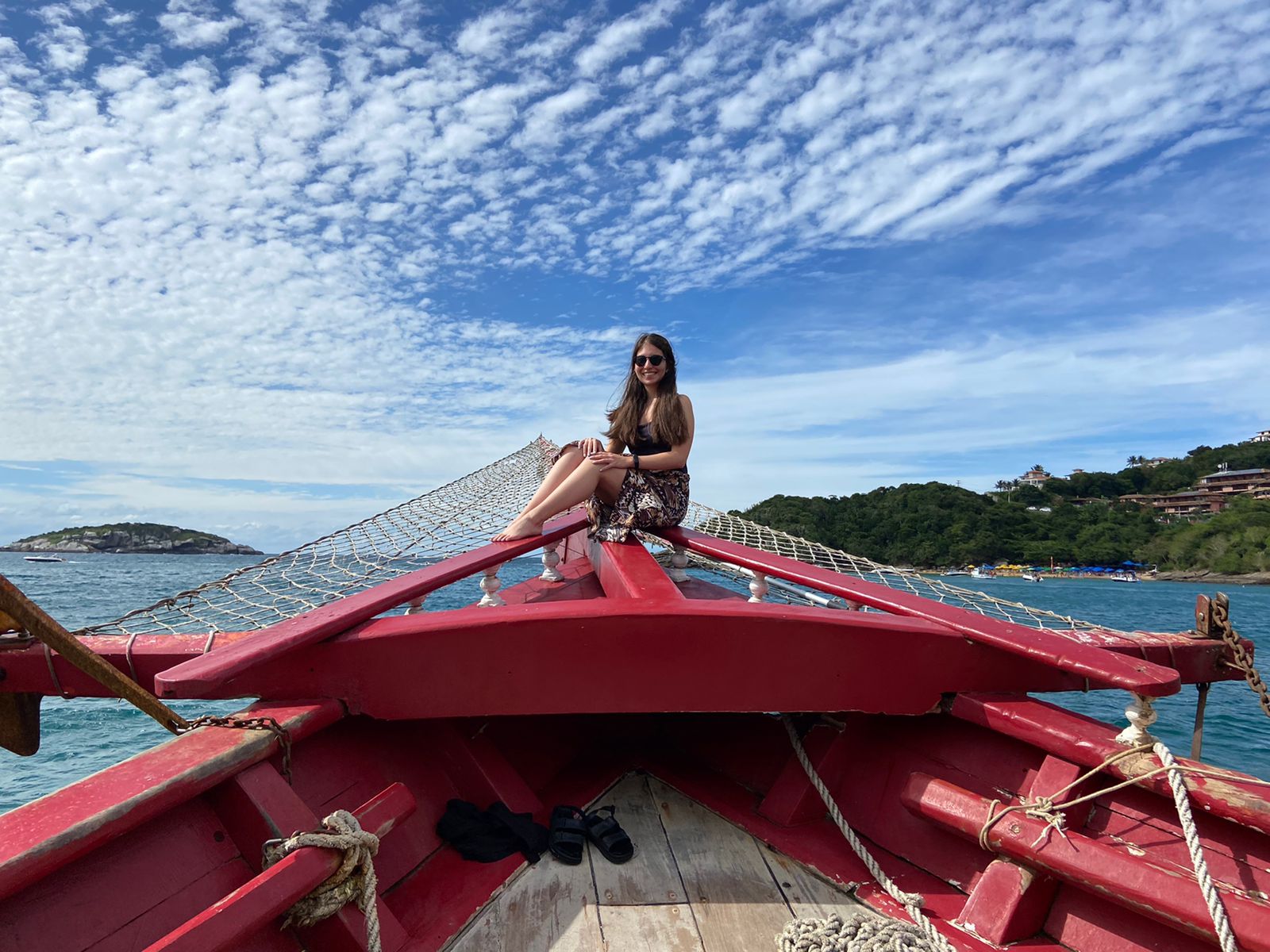 Turista sentada en la proa de la lancha durante el paseo marítimo por Búzios, Brasil