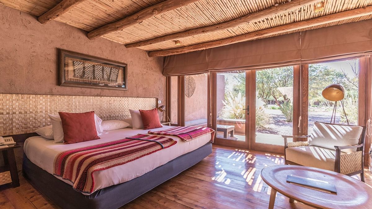 Habitación Hotel Cumbres con techo de cañas y vista a jardín del desierto de Atacama