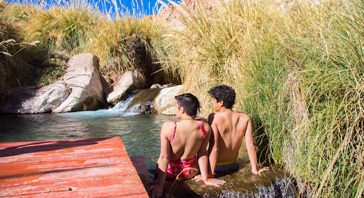 Pareja en las aguas de las termas de puritama en San Pedro de Atacama