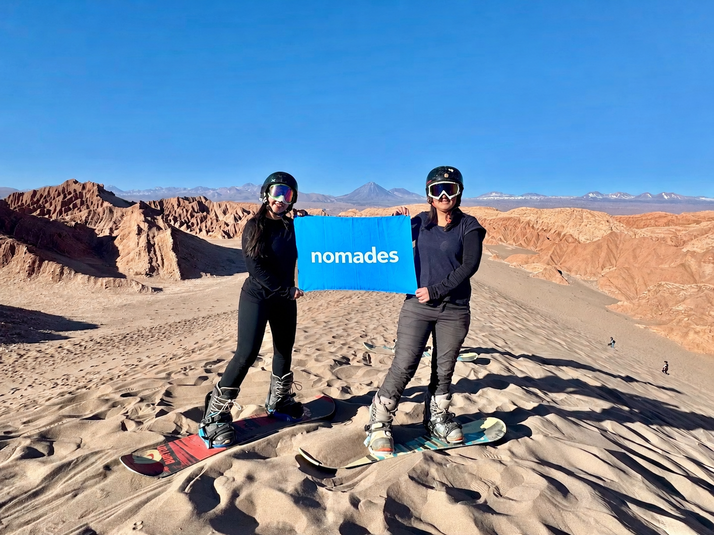 Turistas con bandera Nomades en Sandboard