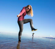 Imagen Salar de Uyuni (4 días) en San Pedro de Atacama Persona en el Salar de Uyuni con efecto espejo haciendo una pose con perspectiva.
