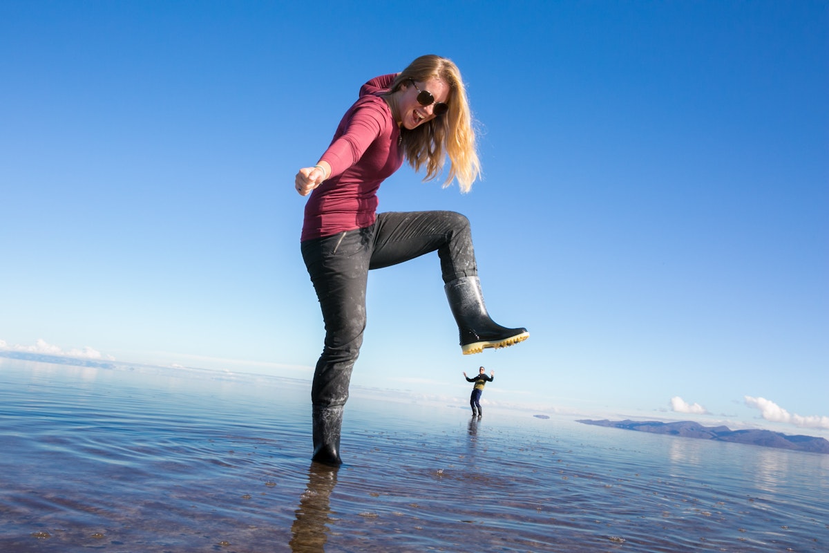 Persona en el Salar de Uyuni con efecto espejo haciendo una pose con perspectiva. Persona en el Salar de Uyuni con efecto espejo haciendo una pose con perspectiva.