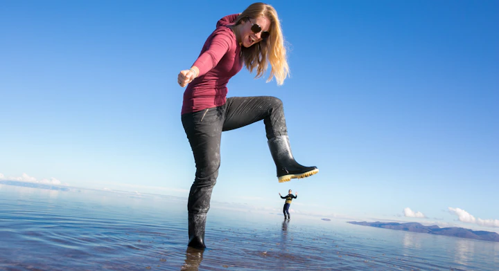 Persona en el Salar de Uyuni con efecto espejo haciendo una pose con perspectiva.