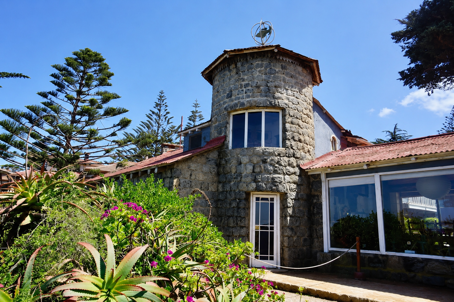 Fachada de piedra con torre y esfera armilar de la Casa Museo de Pablo Neruda en Isla Negra, Chile