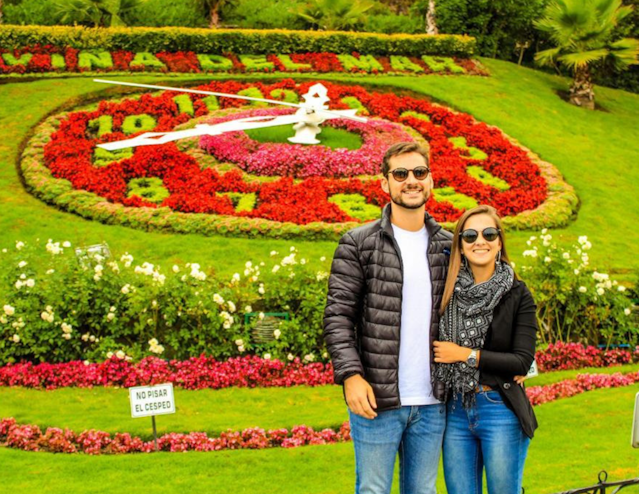 Pareja frente al reloj de flores