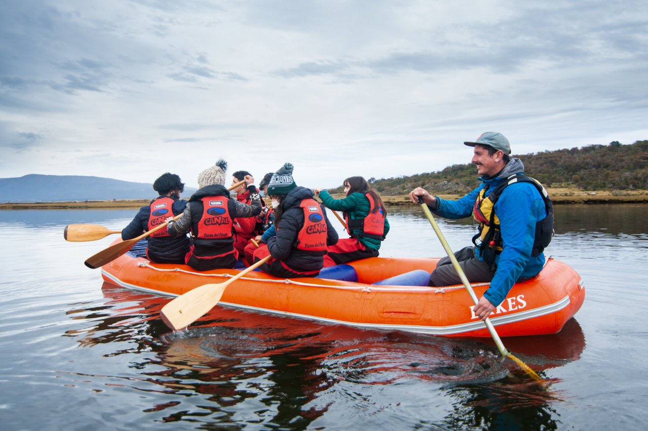 Grupo de turistas remando en canoa inflable por los canales fueguinos rumbo a Isla Gable, Ushuaia