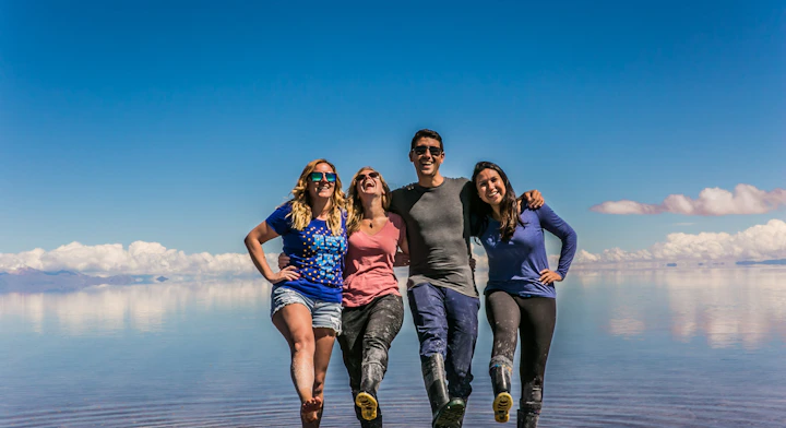Personas sonriendo en el Salar de Uyuni con efecto espejo.