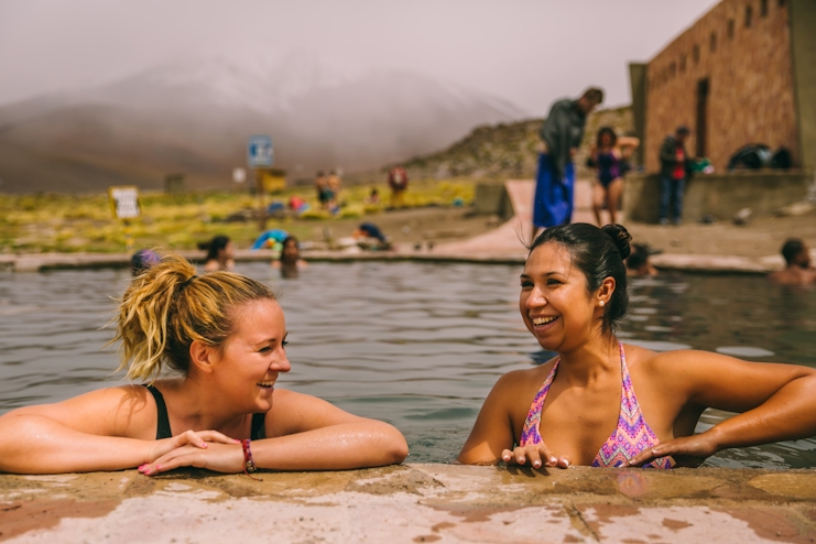 Mujeres sonriendo, tomando un baño en las termas de Polque.