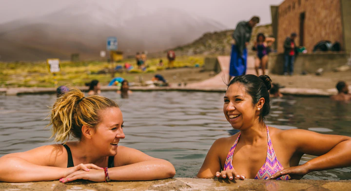 Mujeres sonriendo, tomando un baño en las termas de Polque.