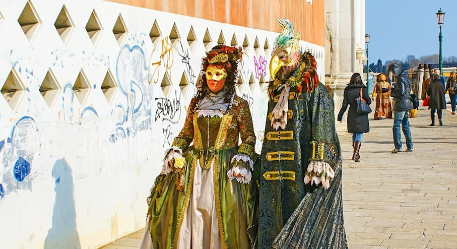 Personas caminando con máscaras del Carnaval de Venecia