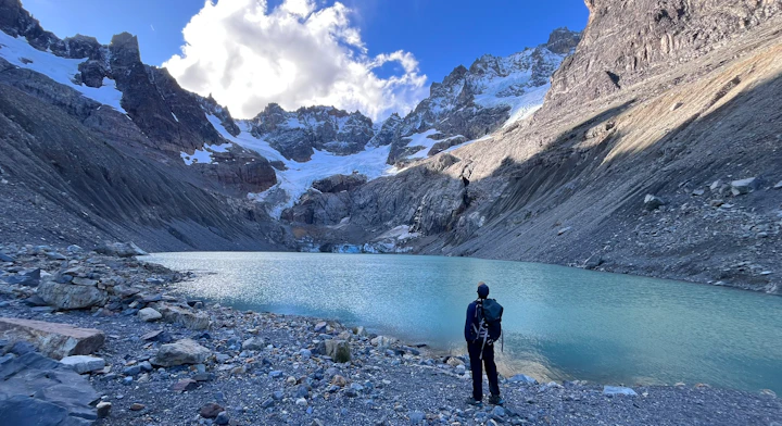 Laguna glaciar en el Circuito Las Horquetas, Cerro Castillo Trekker frente a laguna turquesa glaciar en Circuito Las Horquetas, Cerro Castillo, Patagonia chilena